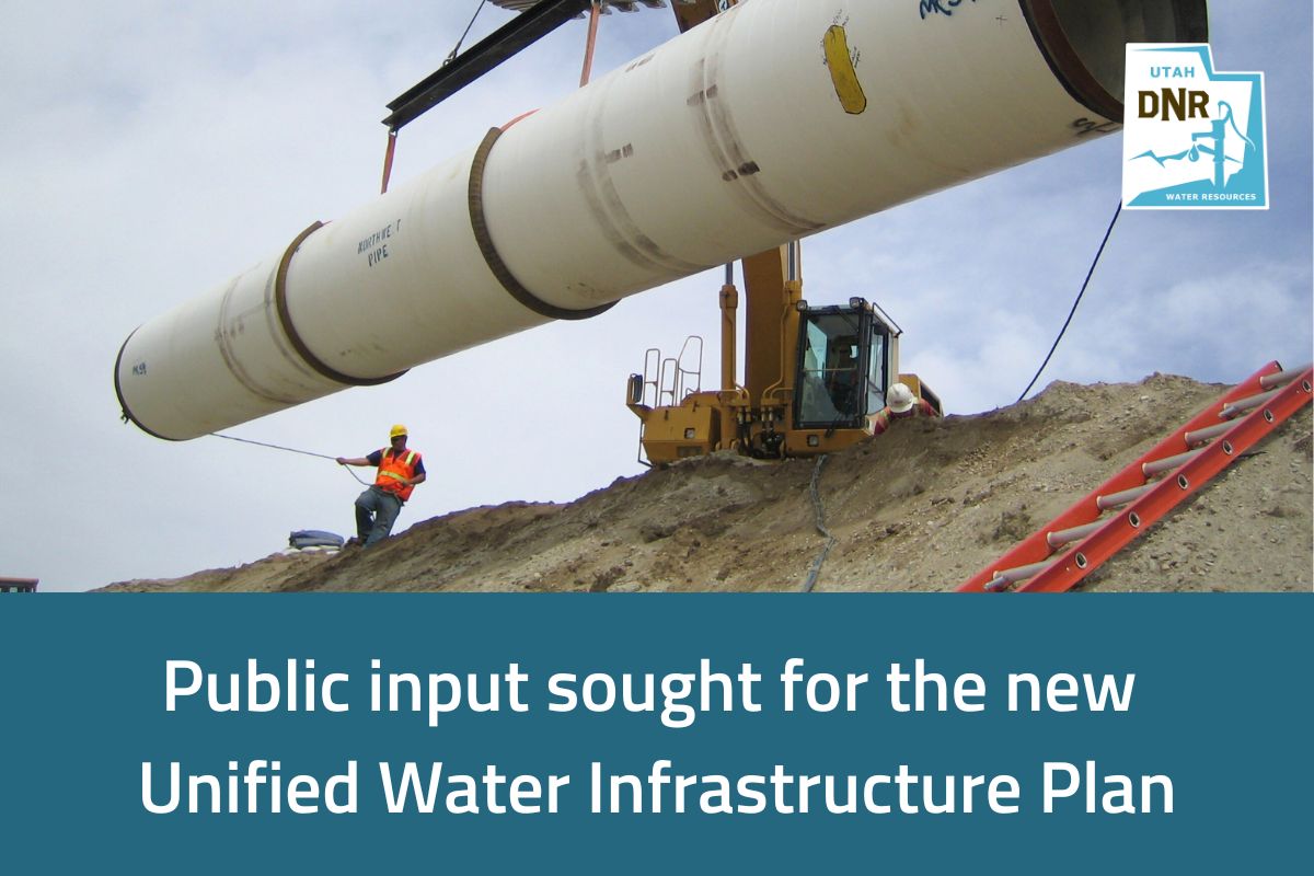 Image shows a large pipe being placed by a crane and a construction worker helping to guide the pipe.